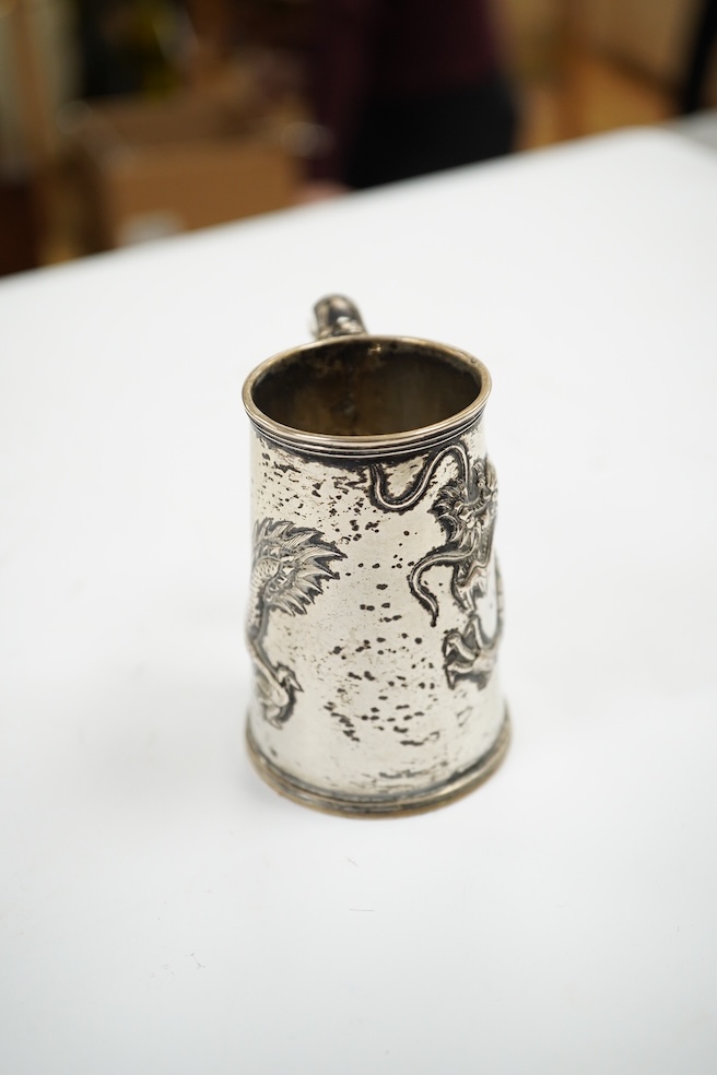 A small Chinese Export white metal mug, embossed with a dragon, 68mm, 66 grams. Condition - fair